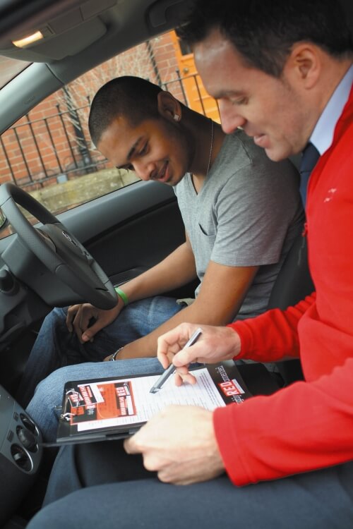 Learner with Red Driving school instructor in car