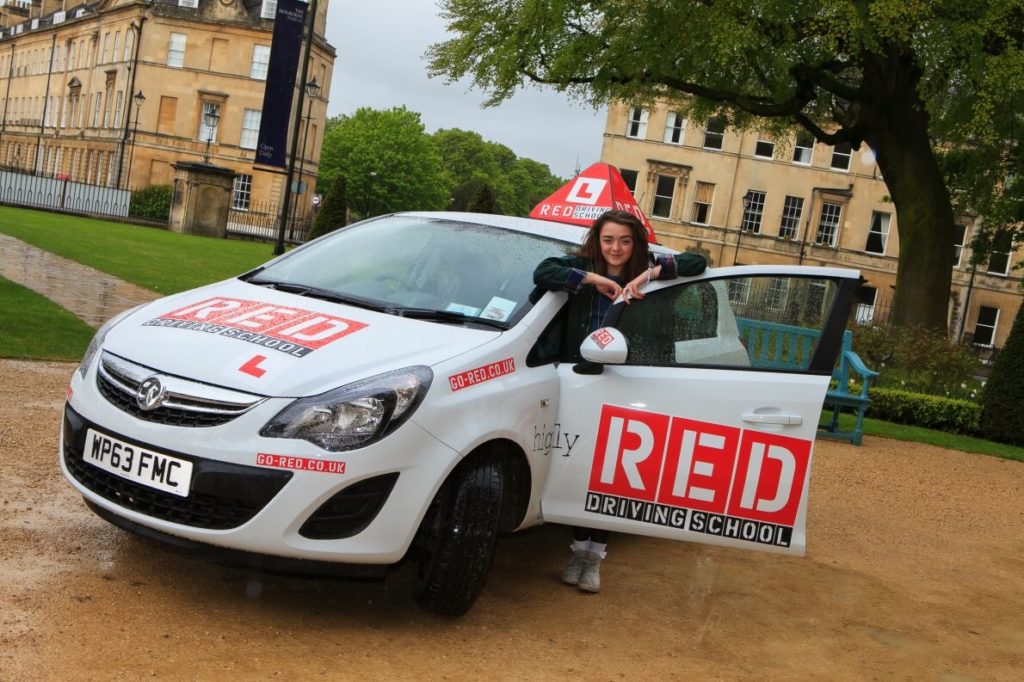 Maisie Williams outside with RED driving school car