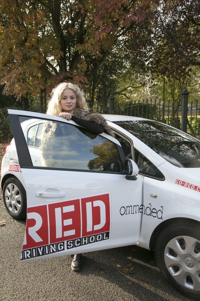 Nina Nesbitt leaning on RED driving school door